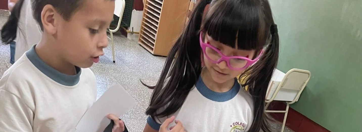 Docente lee un cuento a niños de jardín sentados en ronda durante una actividad en el aula.