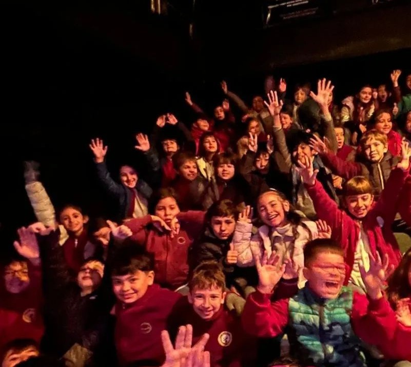 Estudiantes de primaria saludan durante una salida didáctica o actividad cultural del colegio.